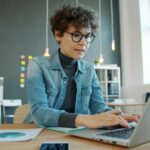 Business owner using a laptop in a modern workspace, representing AI tools and business productivity