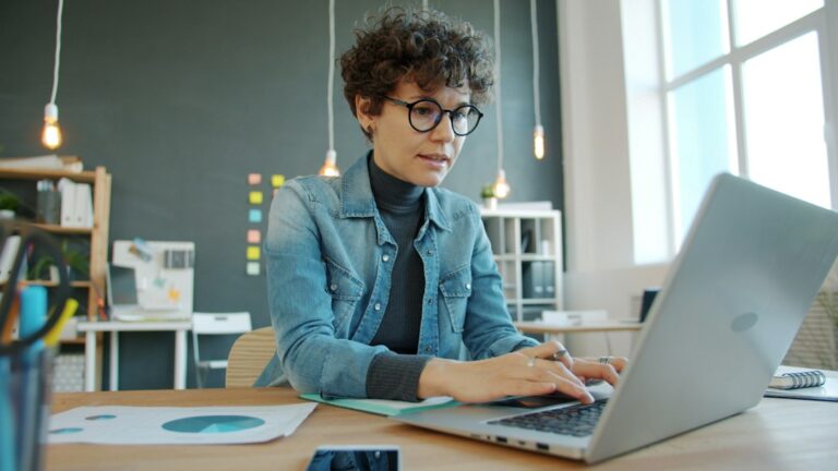 Business owner using a laptop in a modern workspace, representing AI tools and business productivity